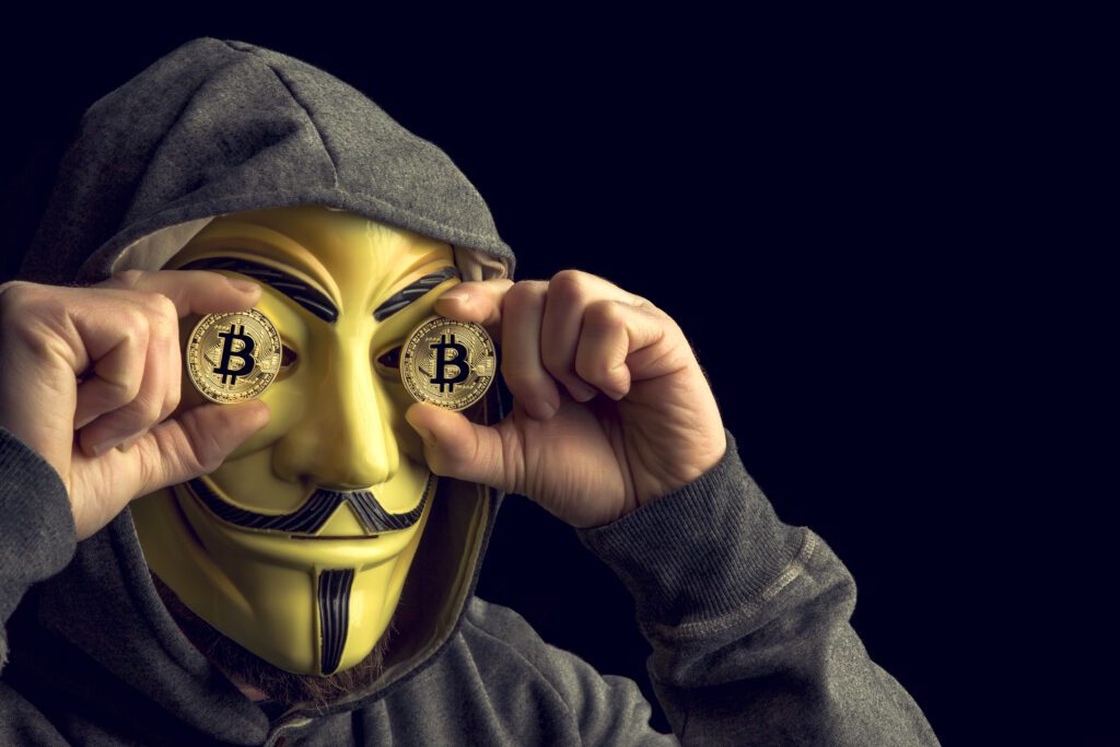 MILAN,ITALY, February, 2018: Hacker old bitcoin coin and wear anonymus mask .Editorial photo.